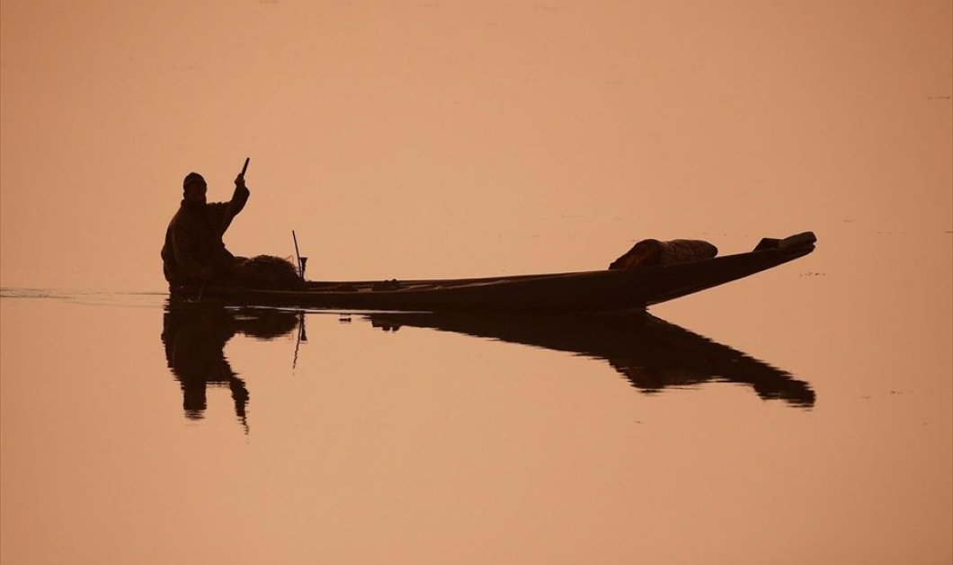 Ψαράς διασχίζει τα νερά της λίμνης Νταλ ένα κρύο πρωινό στη Σριναγκάρ, στην Ινδία - Φωτογραφία: REUTERS / DANISH ISMAIL
